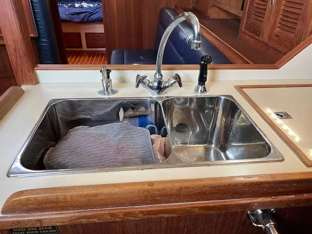  Yacht Photos Pics Kitchen sink area on a 1999 Island Packet 380 yacht, featuring dual basins and wooden cabinetry.