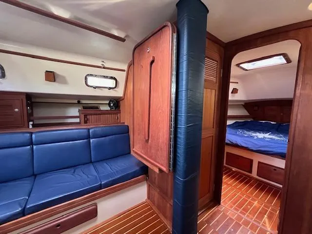  Yacht Photos Pics Interior of 1999 Island Packet 380 sailboat with blue seating and wooden finishes.