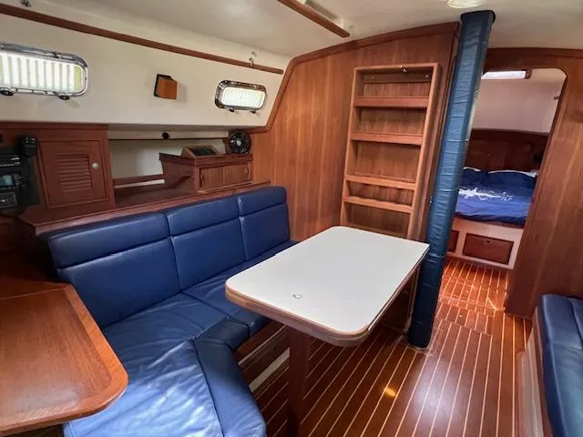  Yacht Photos Pics Interior of 1999 Island Packet 380 sailboat with blue seating and wooden finishes.