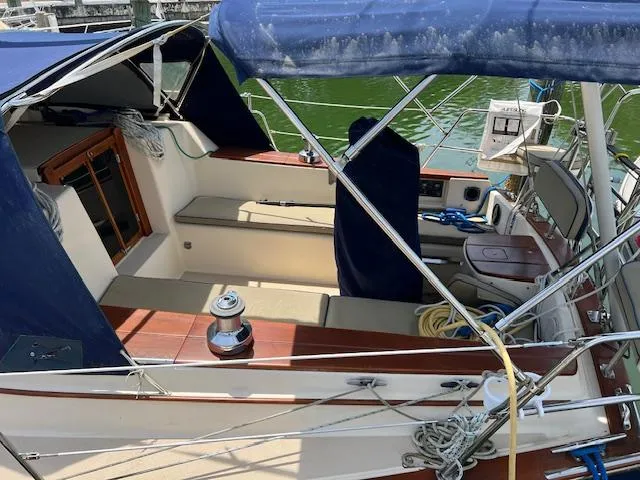  Yacht Photos Pics 1999 Island Packet 380 sailboat cockpit with blue canopy and seating area.