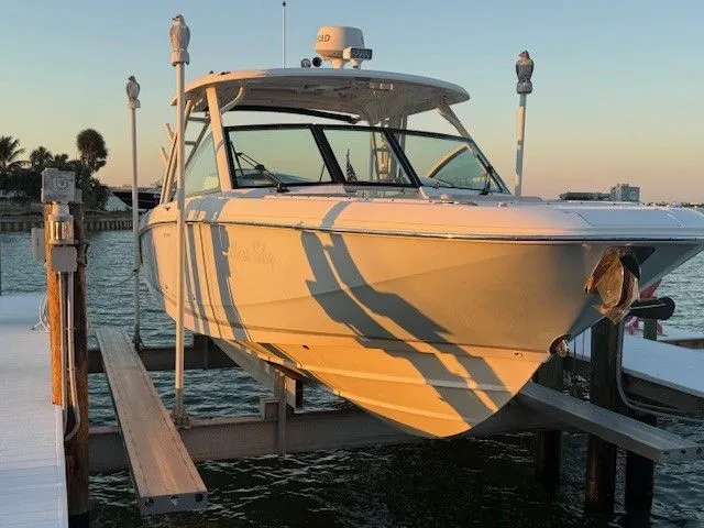  Yacht Photos Pics 2017 Boston Whaler 320 Vantage on a boat lift by the water.