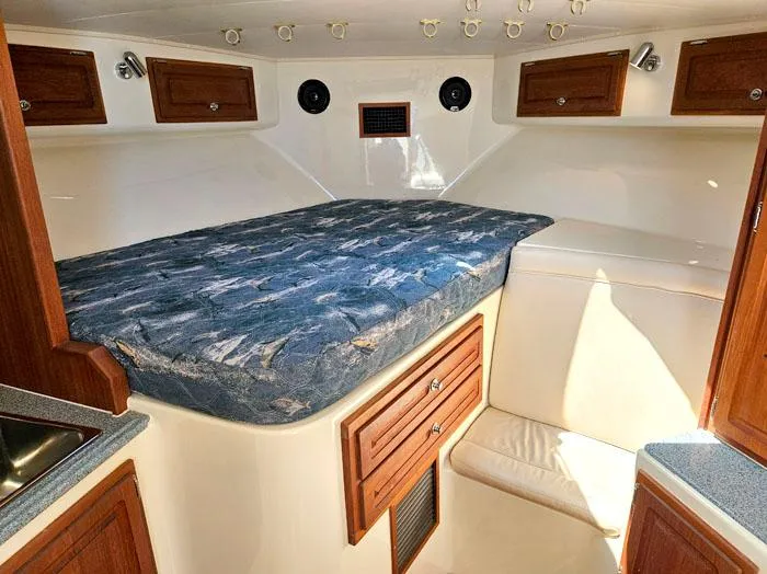  Yacht Photos Pics Interior cabin of a 2001 Carolina Classic Express 35 with bed and wooden cabinets.
