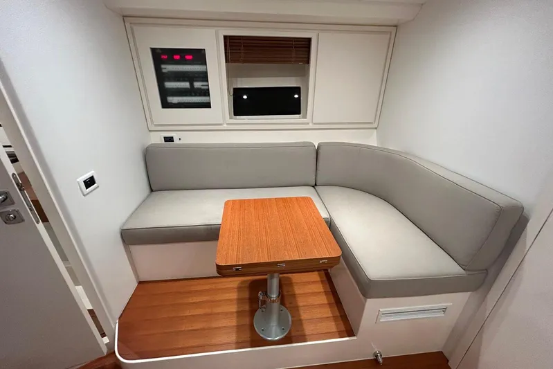  Yacht Photos Pics Modern interior of 2022 Itama 45s yacht with cozy seating and wooden table.
