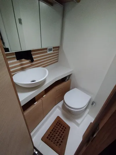 Loic Yacht Photos Pics Modern yacht bathroom with sink, toilet, and wooden accents on Italia Yachts Italia 14.98, 2023.