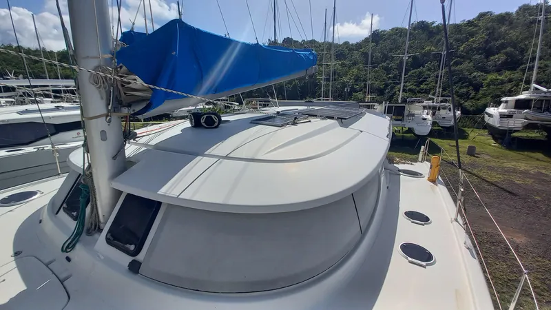 Double Trouble Yacht Photos Pics 2015 Fountaine Pajot Lipari 41 catamaran with blue sail cover, docked near lush greenery.