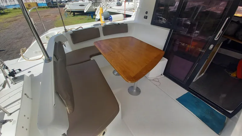 Double Trouble Yacht Photos Pics 2015 Fountaine Pajot Lipari 41 catamaran cockpit with cushioned seating and wooden table.