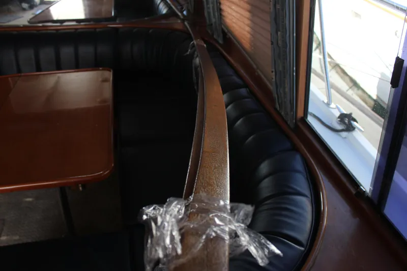 Ocean Eyes Yacht Photos Pics Interior of a 1994 Mikelson 64 yacht with leather seating and wooden table.
