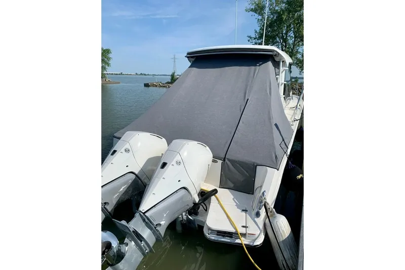  Yacht Photos Pics 2022 Boston Whaler 325 Conquest boat docked with covered deck and dual outboard engines.