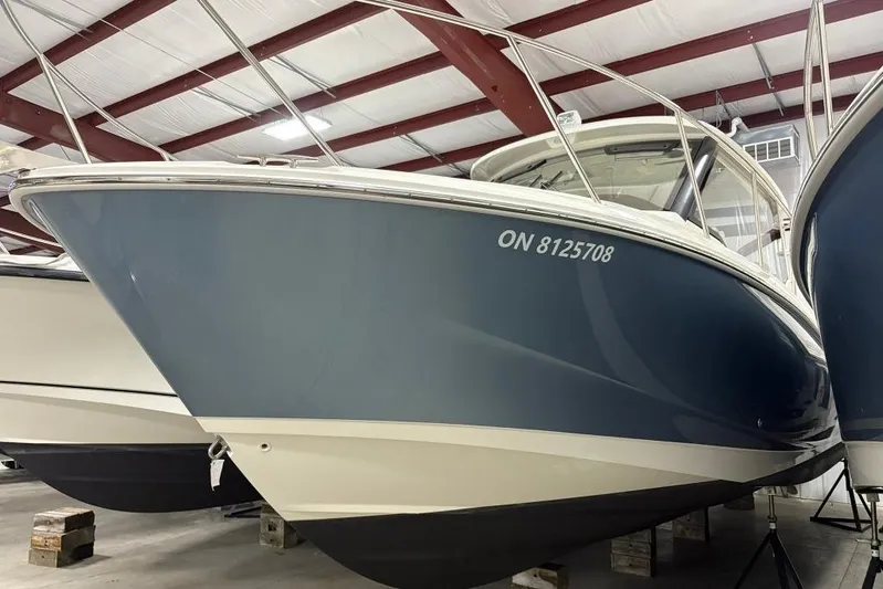  Yacht Photos Pics 2022 Boston Whaler 325 Conquest boat in storage, blue hull, indoor facility.