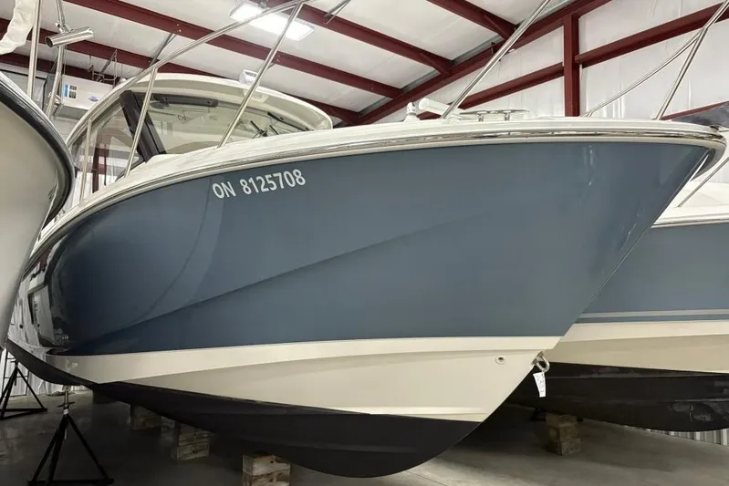  Yacht Photos Pics 2022 Boston Whaler 325 Conquest boat in storage, blue hull, indoor facility.