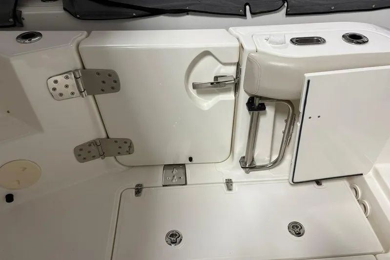 Yacht Photos Pics 2022 Boston Whaler 325 Conquest boat interior, featuring white seating and storage compartments.