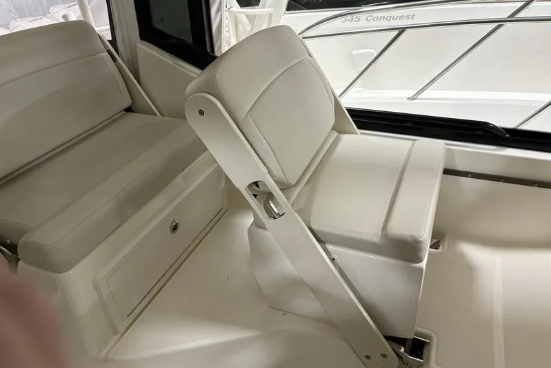  Yacht Photos Pics 2022 Boston Whaler 325 Conquest interior seating with white upholstery and storage compartment.