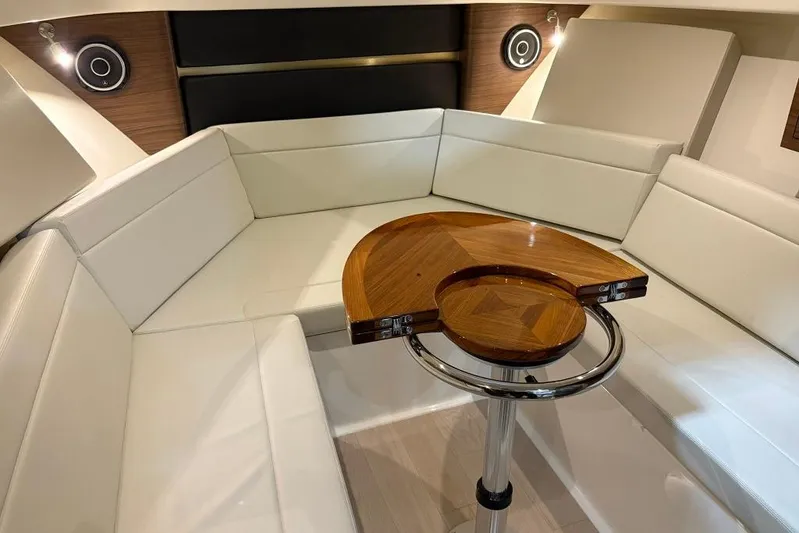  Yacht Photos Pics 2022 Boston Whaler 325 Conquest interior with white seating and wooden table.