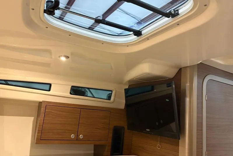  Yacht Photos Pics Interior of 2022 Boston Whaler 325 Conquest with wood cabinets and ceiling hatch.