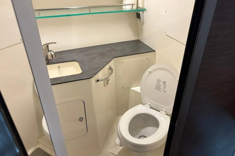  Yacht Photos Pics 2022 Boston Whaler 325 Conquest bathroom with sink, toilet, and modern countertop design.