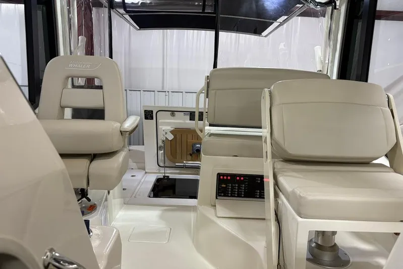  Yacht Photos Pics 2022 Boston Whaler 325 Conquest interior with beige seating and control panel.