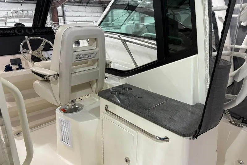  Yacht Photos Pics 2022 Boston Whaler 325 Conquest helm with steering wheel and seating in a sleek interior.