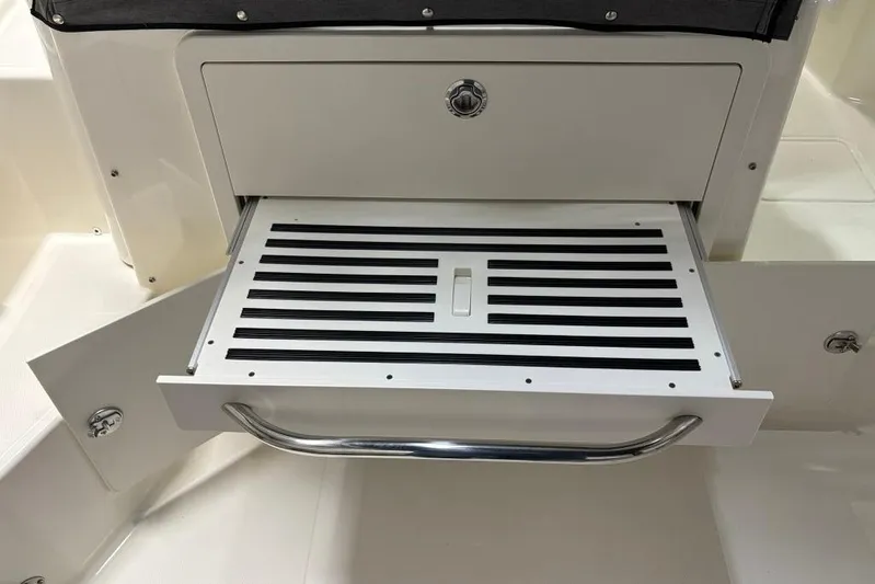  Yacht Photos Pics 2022 Boston Whaler 325 Conquest boat storage compartment with pull-out tray and handle.