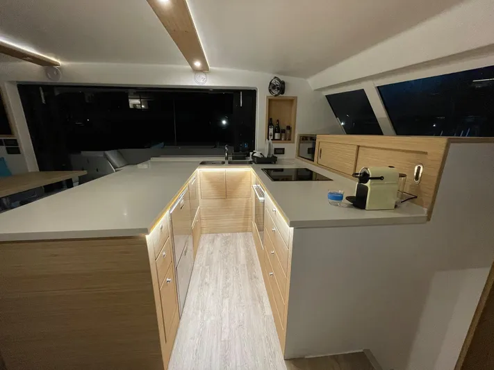  Yacht Photos Pics Modern kitchen interior of Ocean Renegade R5 MKII 2025 yacht with sleek countertops and wooden cabinets.