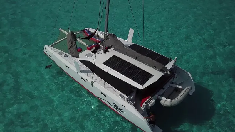  Yacht Photos Pics Aerial view of 2025 Ocean Renegade R5 MKII catamaran sailing in clear turquoise waters.