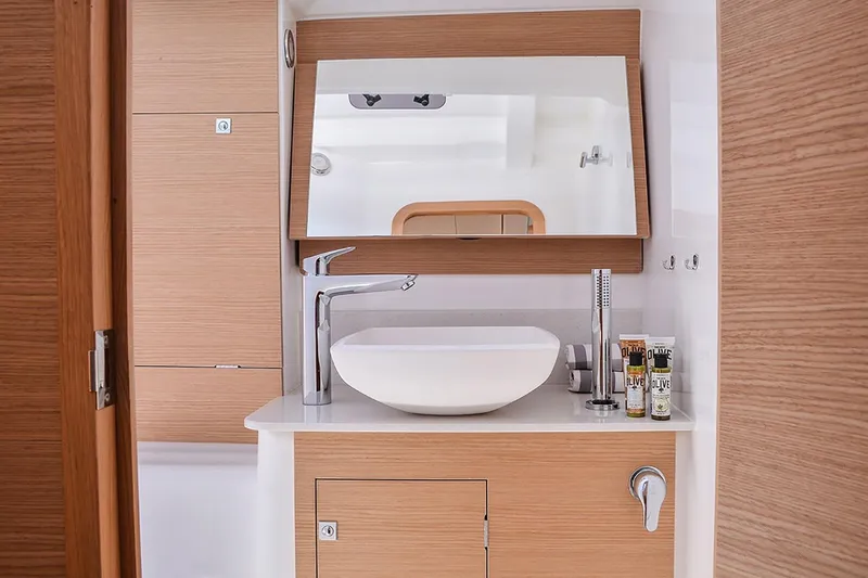  Yacht Photos Pics Modern bathroom interior of 2019 Dufour 460 Grand Large yacht with sleek sink and mirror.