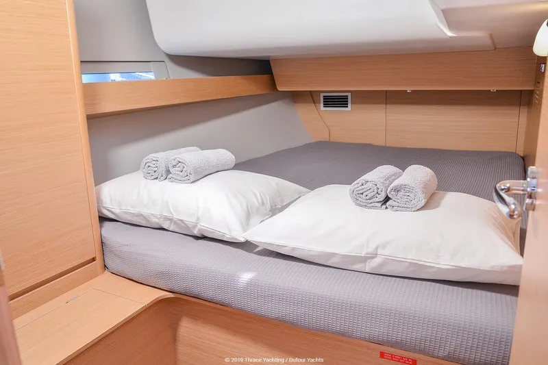  Yacht Photos Pics Cozy cabin interior of 2019 Dufour 460 Grand Large yacht with neatly arranged bedding.