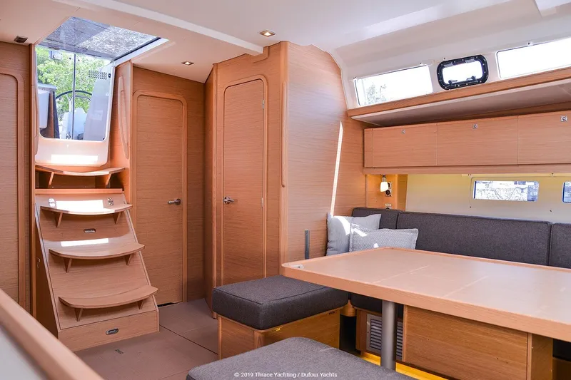  Yacht Photos Pics Interior of 2019 Dufour 460 Grand Large yacht with modern wood finish and seating area.