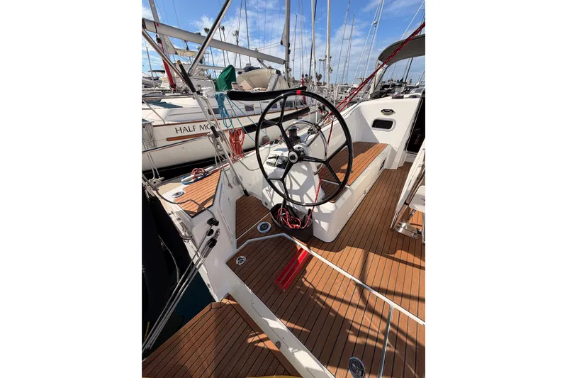 C'est Chic Yacht Photos Pics 2025 Jeanneau Sun Odyssey 350 sailboat cockpit with wooden deck and steering wheel.
