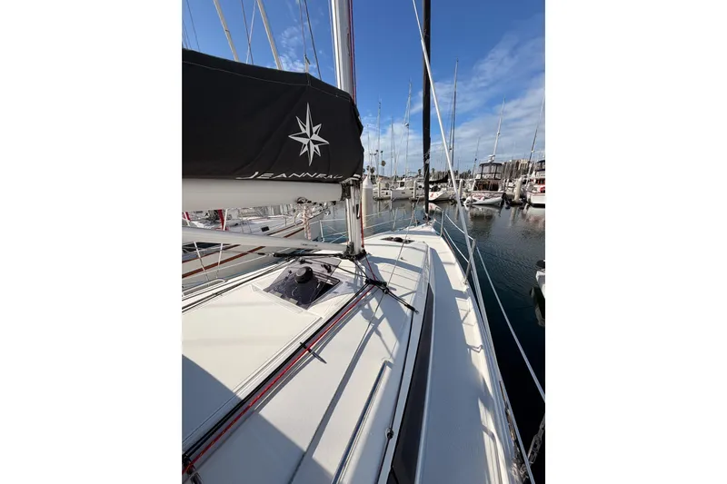 C'est Chic Yacht Photos Pics 2025 Jeanneau Sun Odyssey 350 sailboat docked in marina, clear sky, calm waters.