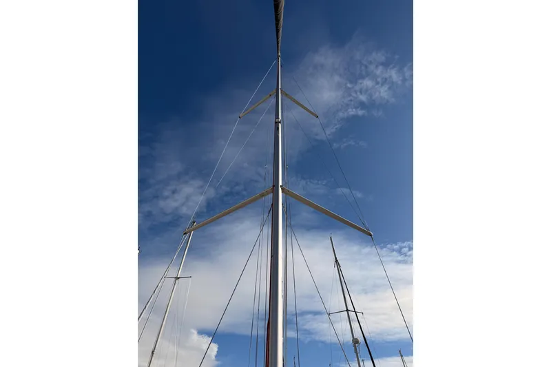 C'est Chic Yacht Photos Pics Mast of 2025 Jeanneau Sun Odyssey 350 sailboat against a clear blue sky.