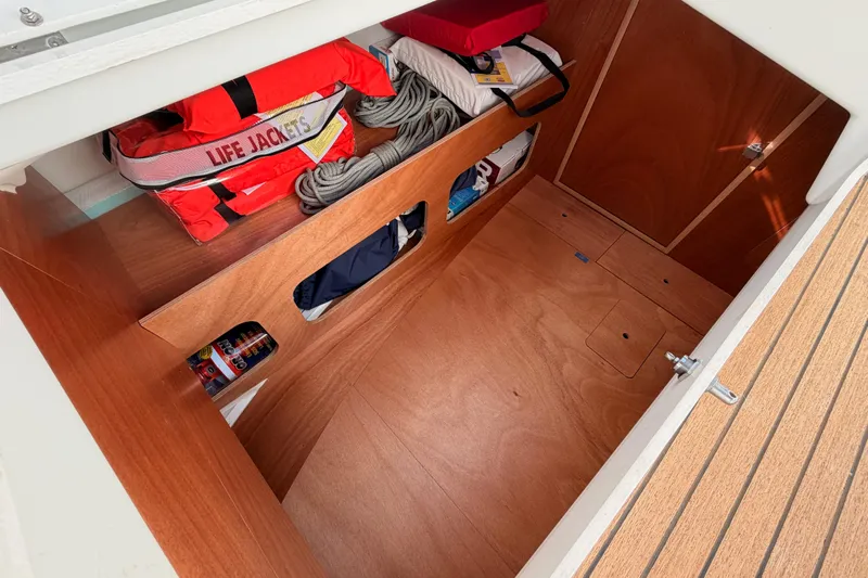 C'est Chic Yacht Photos Pics 2025 Jeanneau Sun Odyssey 350 storage area with life jackets and ropes.