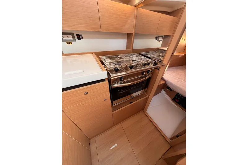 C'est Chic Yacht Photos Pics 2025 Jeanneau Sun Odyssey 350 yacht kitchen with modern appliances and wood cabinetry.