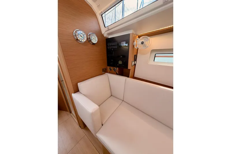 C'est Chic Yacht Photos Pics Interior of 2025 Jeanneau Sun Odyssey 350 yacht with white seating and wooden accents.