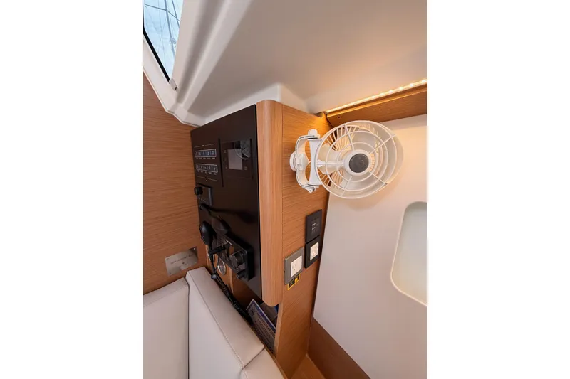 C'est Chic Yacht Photos Pics 2025 Jeanneau Sun Odyssey 350 interior with control panel and mounted fan.