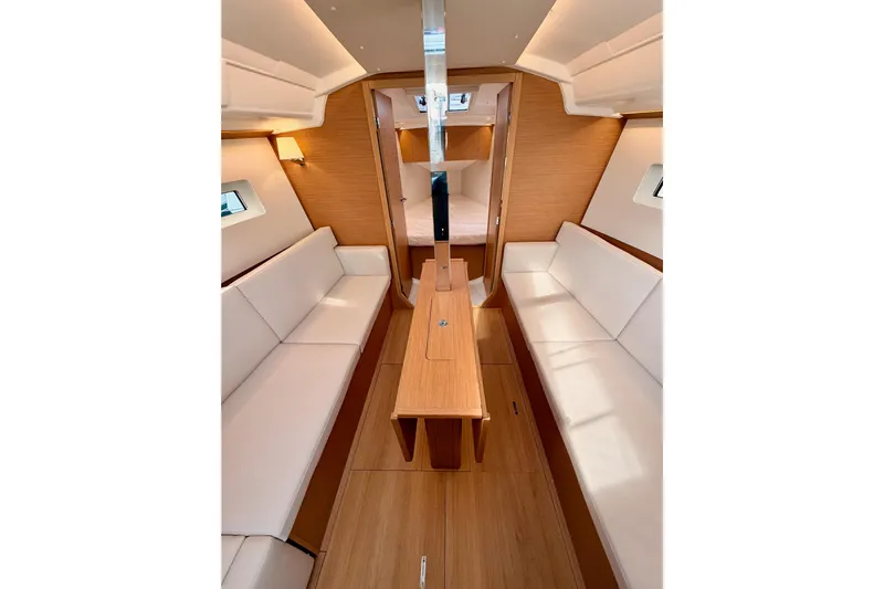 C'est Chic Yacht Photos Pics Interior of 2025 Jeanneau Sun Odyssey 350 sailboat with modern wood finish and white seating.