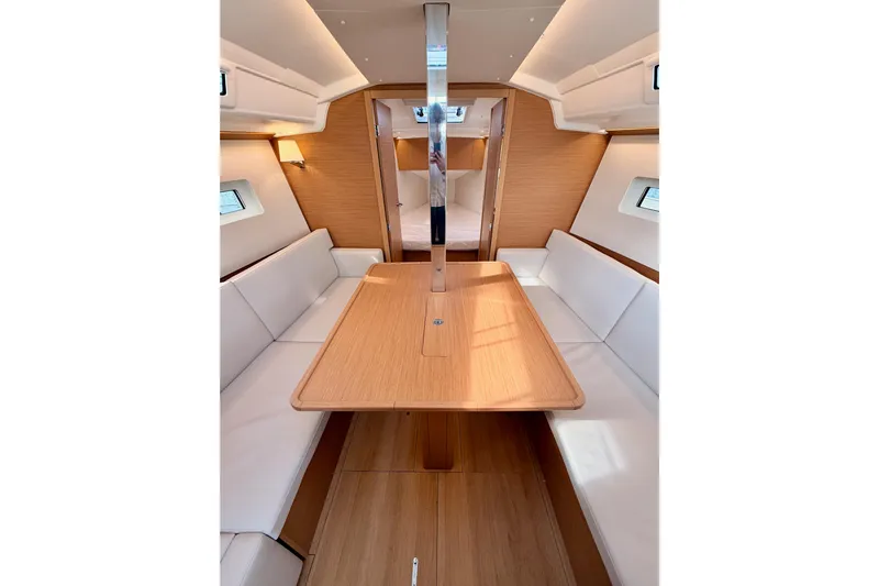 C'est Chic Yacht Photos Pics Interior of 2025 Jeanneau Sun Odyssey 350, featuring elegant wood finishes and comfortable seating.