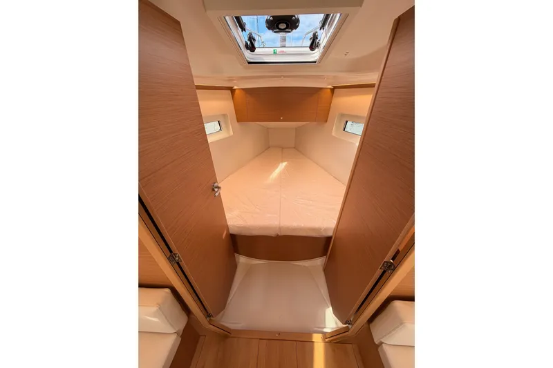 C'est Chic Yacht Photos Pics Interior cabin of 2025 Jeanneau Sun Odyssey 350 sailboat, featuring cozy sleeping quarters.