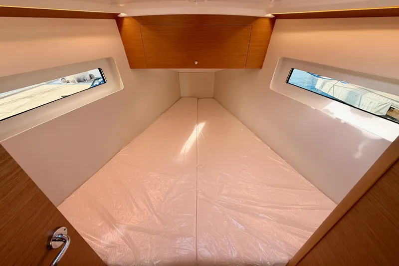 C'est Chic Yacht Photos Pics 2025 Jeanneau Sun Odyssey 350 cabin interior with windows and wooden cabinetry.