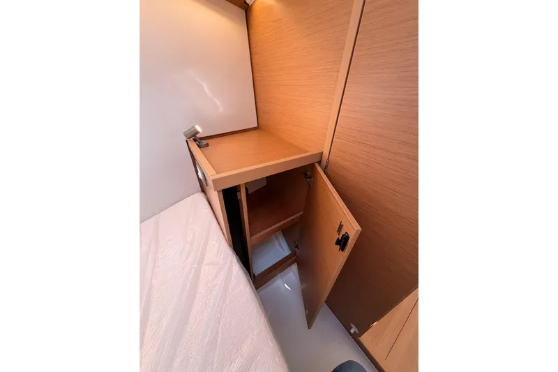 C'est Chic Yacht Photos Pics 2025 Jeanneau Sun Odyssey 350 cabin interior with open wooden storage cabinet.