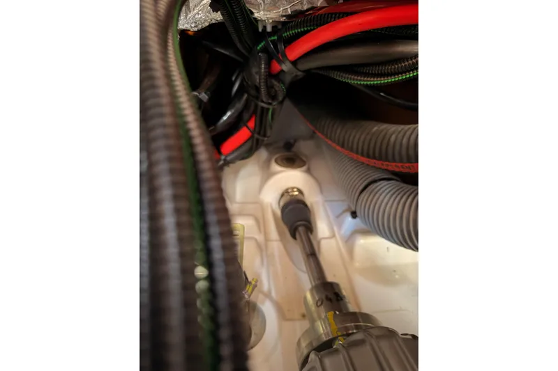 C'est Chic Yacht Photos Pics Engine compartment of 2025 Jeanneau Sun Odyssey 350 sailboat, showing cables and components.