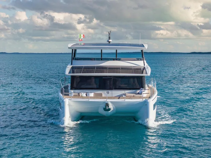  Yacht Photos Pics Silent 62 yacht cruising on open sea, 2026 model, with solar panels and flags.