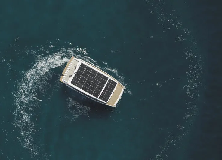  Yacht Photos Pics Aerial view of 2026 Silent 62 yacht with solar panels on blue ocean.