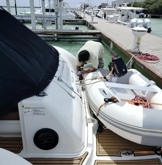 Marcello Yacht Photos Pics Man working on a 2008 Sea Ray Sundancer yacht docked beside an inflatable boat.