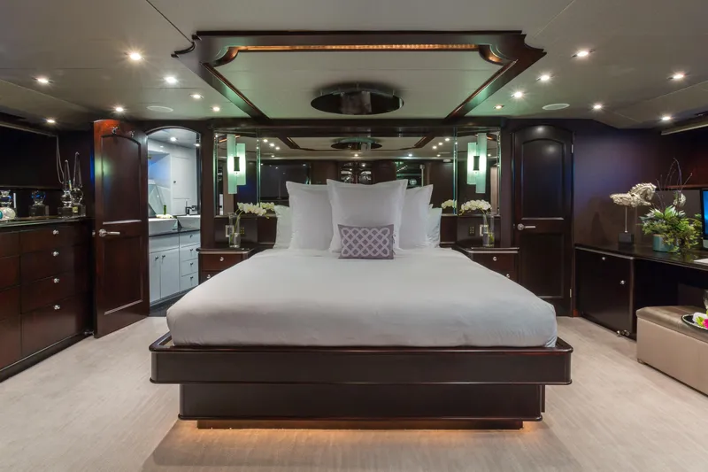 Unbridled Yacht Photos Pics Luxurious bedroom interior on a 1995 Crescent 116 yacht, featuring elegant dark wood and modern decor.