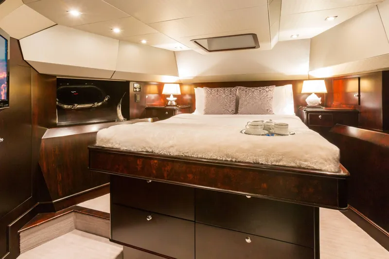Unbridled Yacht Photos Pics Luxurious bedroom interior on 1995 Crescent 116 yacht, featuring elegant bedding and ambient lighting.