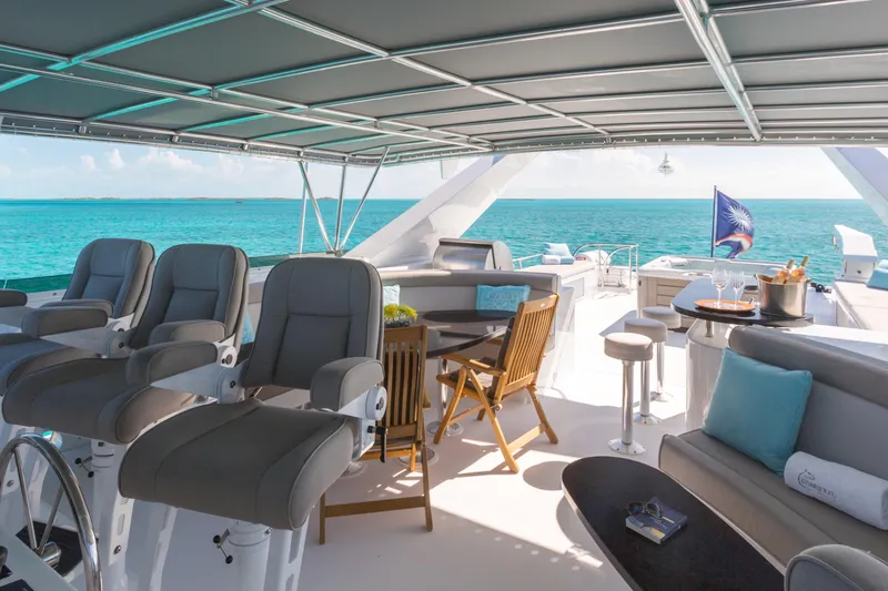 Unbridled Yacht Photos Pics Luxurious Crescent 116 yacht deck with seating, ocean view, and elegant dining setup.