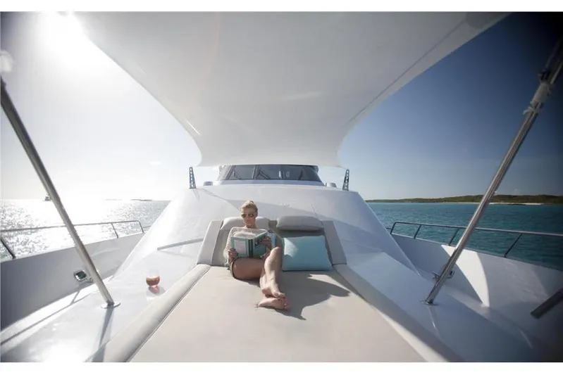 Unbridled Yacht Photos Pics Woman relaxing on Crescent 116 yacht, reading a book under the sun, 1995 model.