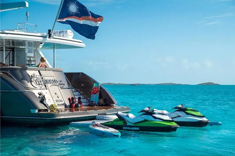 Unbridled Yacht Photos Pics Luxury yacht Crescent 116 with jet skis in turquoise waters, 1995 model.