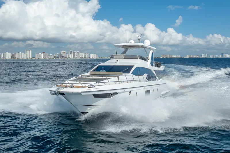  Yacht Photos Pics 2019 Azimut 66 yacht cruising on open water with city skyline backdrop.