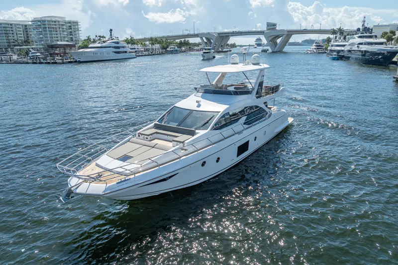  Yacht Photos Pics 2019 Azimut 66 yacht cruising in a sunny marina with bridge and buildings.